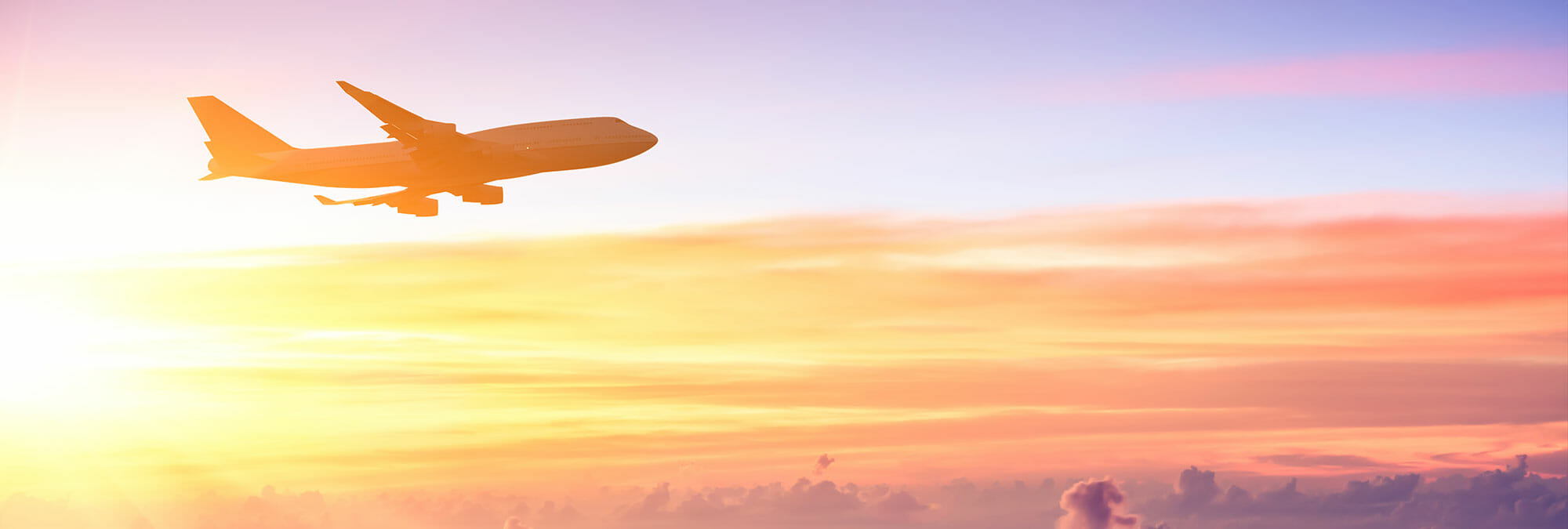 An airplane flying clouds above during sunrise